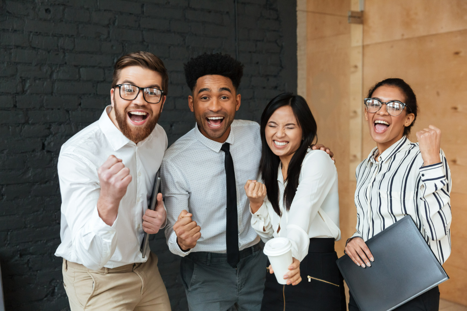 4 jovéns em pé representando a diversidade e inclusão nas empresas