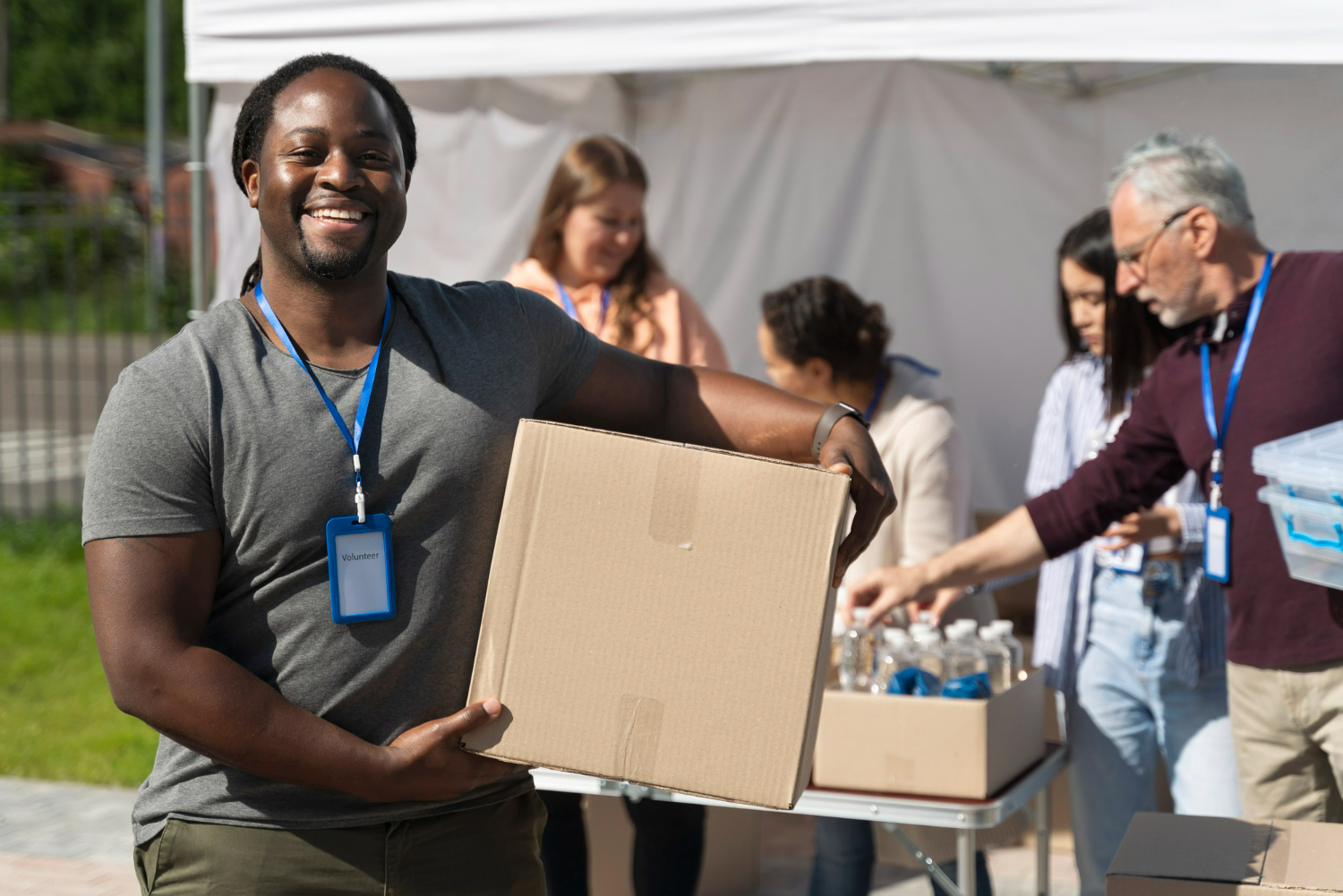 Homem negro segurando uma caixa em programa de voluntariado