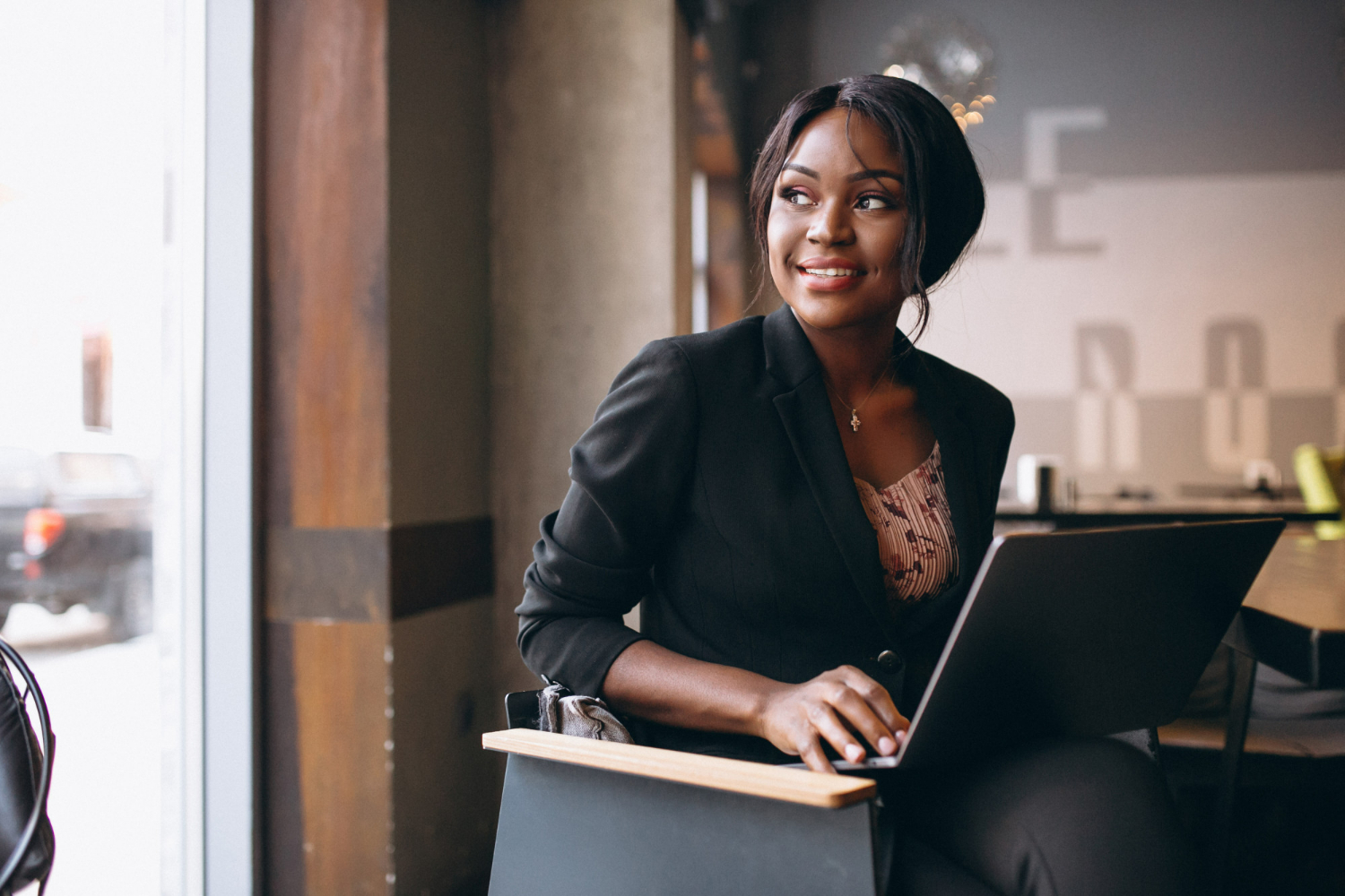 mulher negra sentada trabalhando com notebook apresentando a Desigualdade de gênero